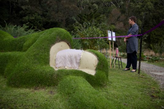 Celai Wad-Brown reads the description of Grant Lyon's "Yeah Nah" living sculpture.