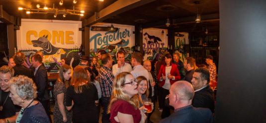 a crowd shot of the upstairs bar, showing half the men without beards