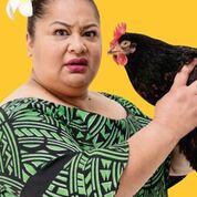 Woman holding a a black chicken. They both look towards the camera.