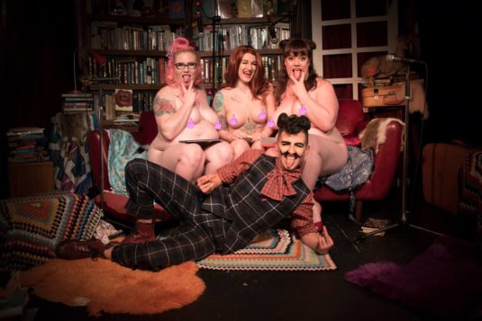 three naked women and a drag king, nipples covered with emoji