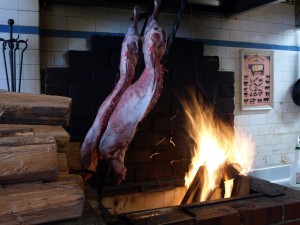 The lamb stats to cook over the open fire of the asador.