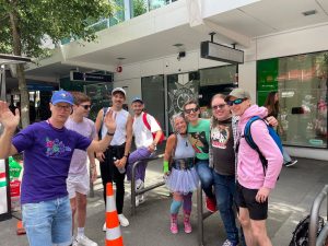 Jeremy with a group of friends hugging on the street